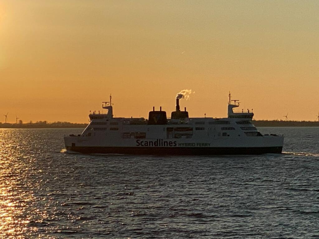 Silhuett av en Scandlines hybridfärja mot solnedgången
