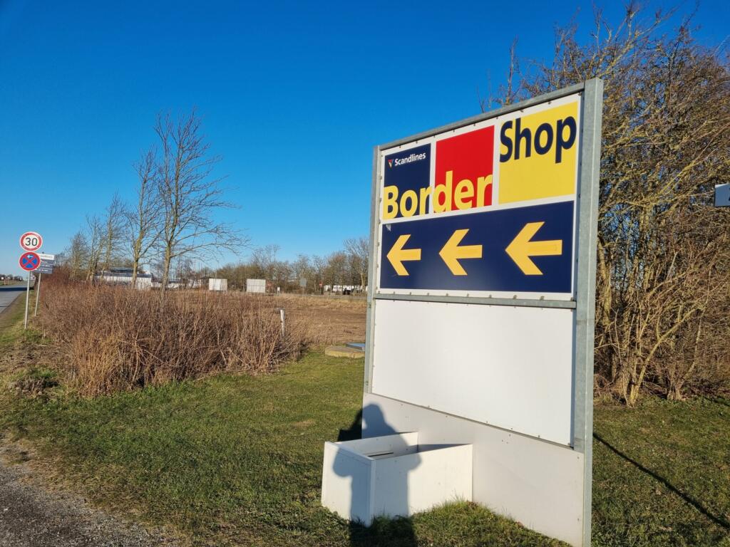 BorderShop sign with arrows at the entrance to Puttgarden port
