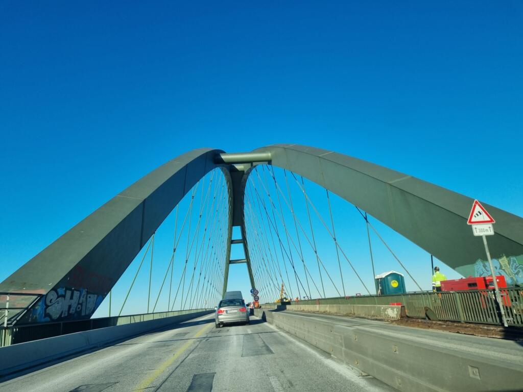 Driving under the steel arch of the Fehmarnsund Bridge
