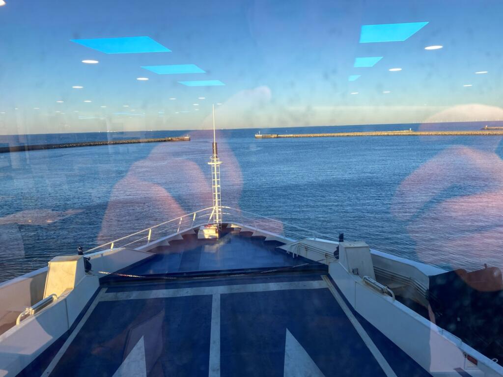 View over the bow as the ferry leaves the breakwaters of Puttgarden