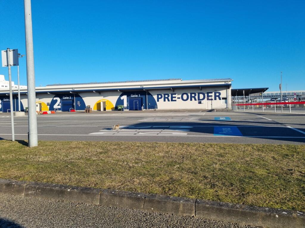 The pre-order pick-up building in Puttgarden with a Scandlines ferry behind it