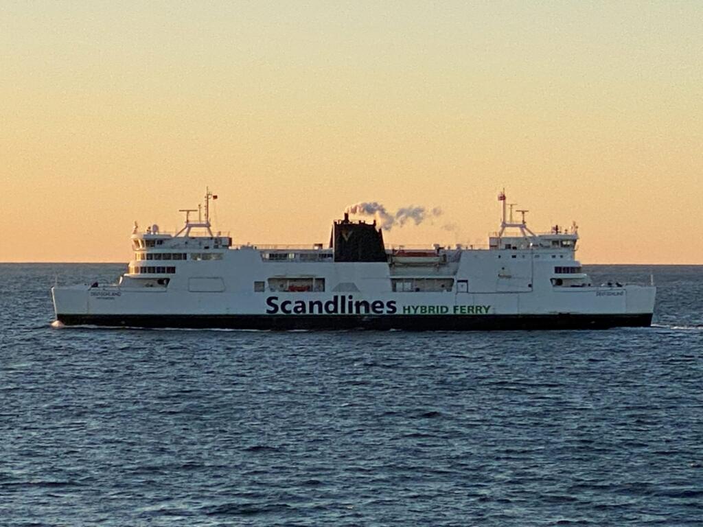 A Scandlines hybrid ferry passing on the Fehmarnbelt at sunset